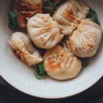 Vegane Dumplings in einer Schüssel mit Frühlingszwiebeln