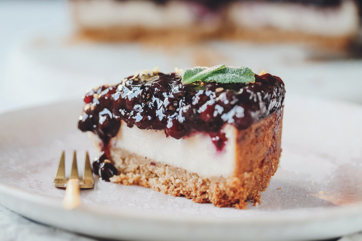 Blueberry Cheesecake auf rosa Teller mit goldener Gabel