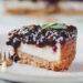 Blueberry Cheesecake auf rosa Teller mit goldener Gabel