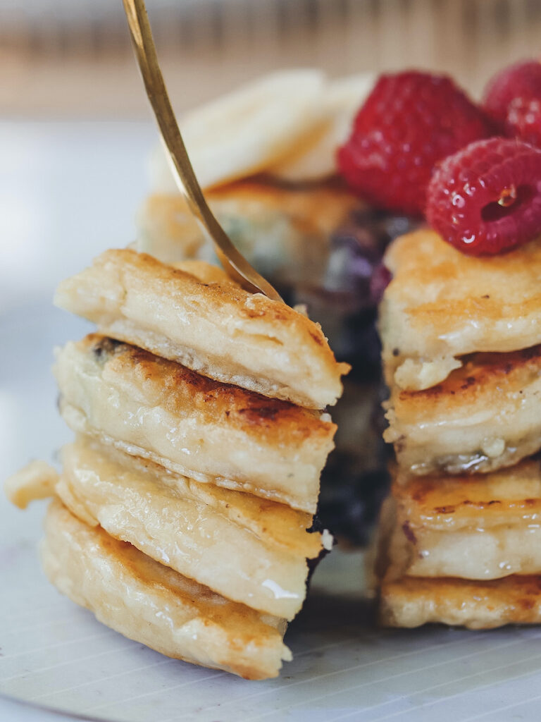 Vegane Protein Pancakes Stapel mit Beeren angeschnitten